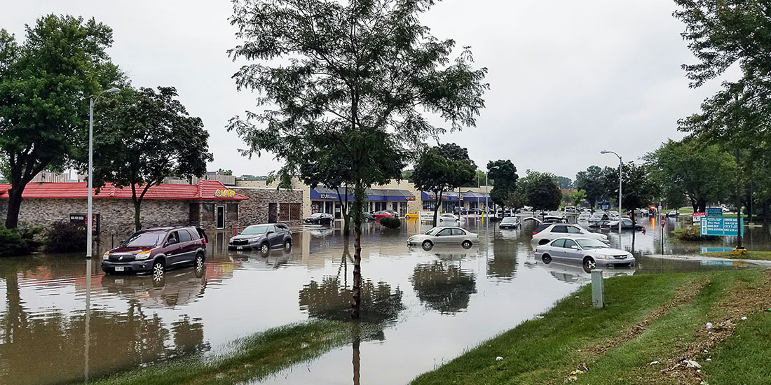 shopping center with flooded parking lot and stranded vehicles